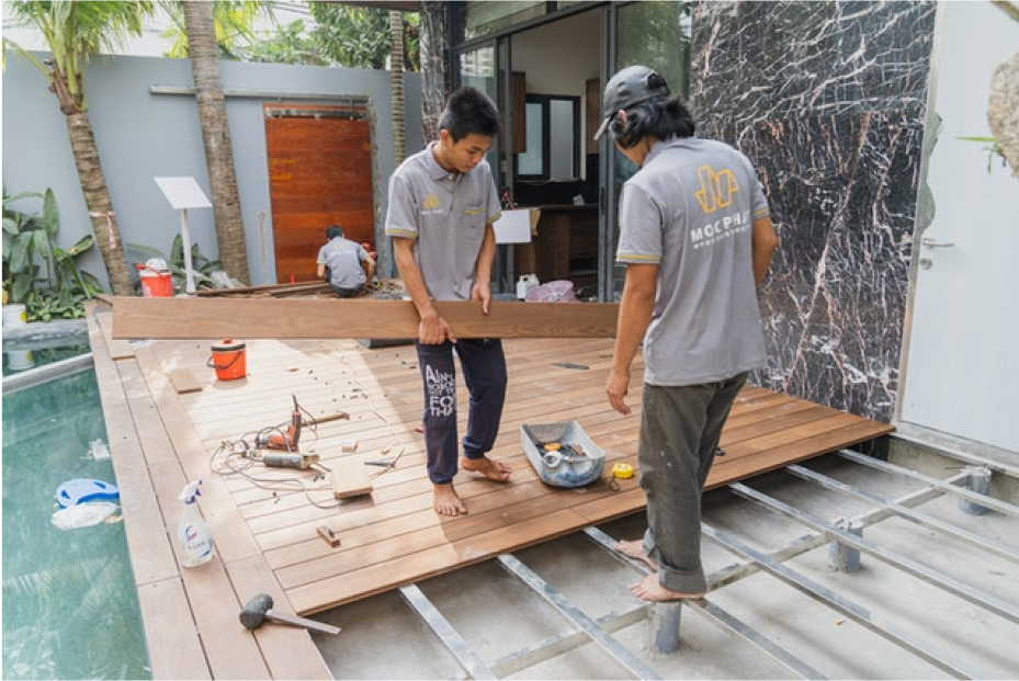 two men repairing outdoors